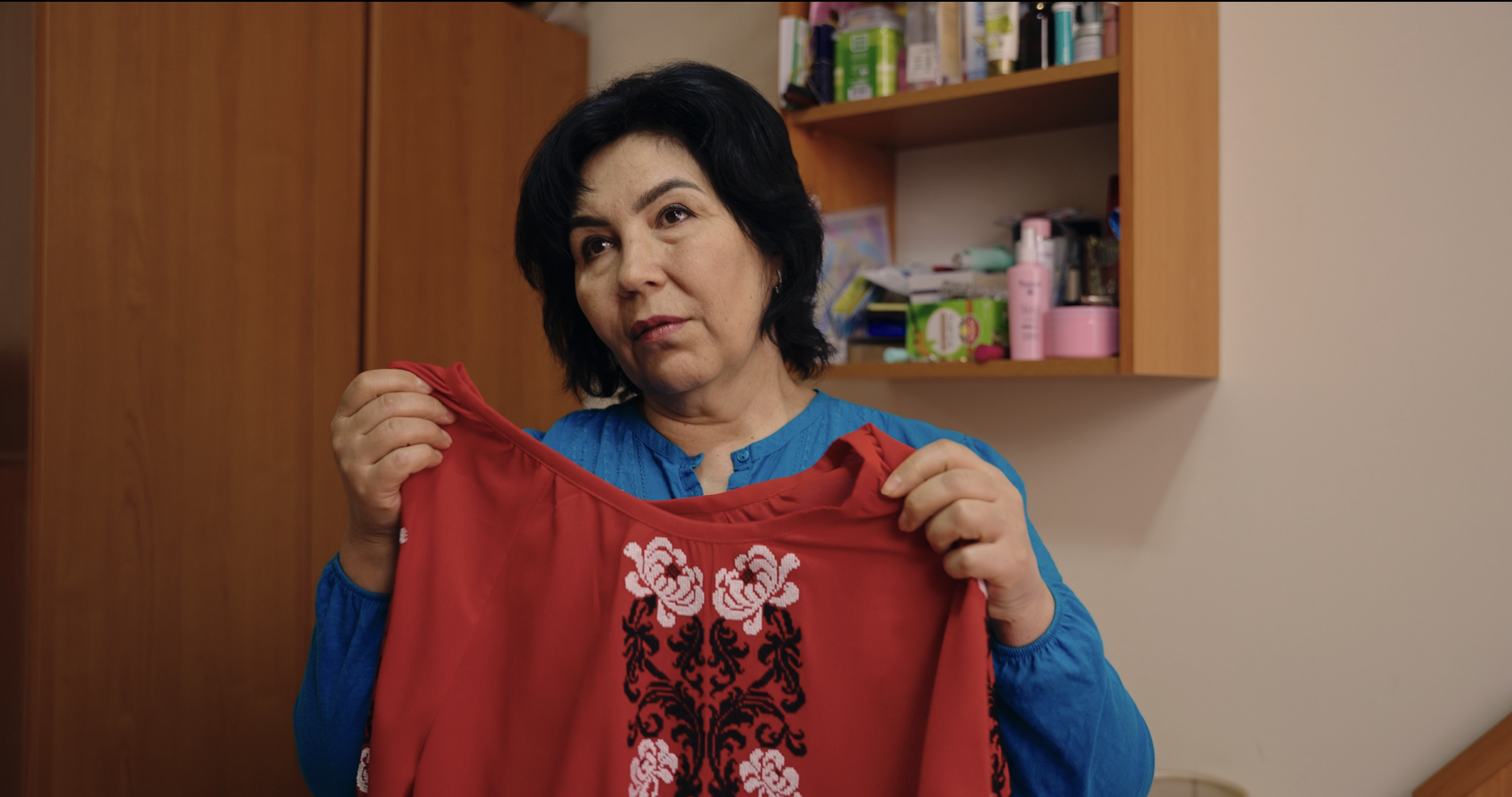 After being abducted by Russian forces, Leila Ibrahimova holds the red vyshyvanka blouse she wore in the photo the Bariievs used in their campaign to rescue her. She credits the Bariievs with saving her life.