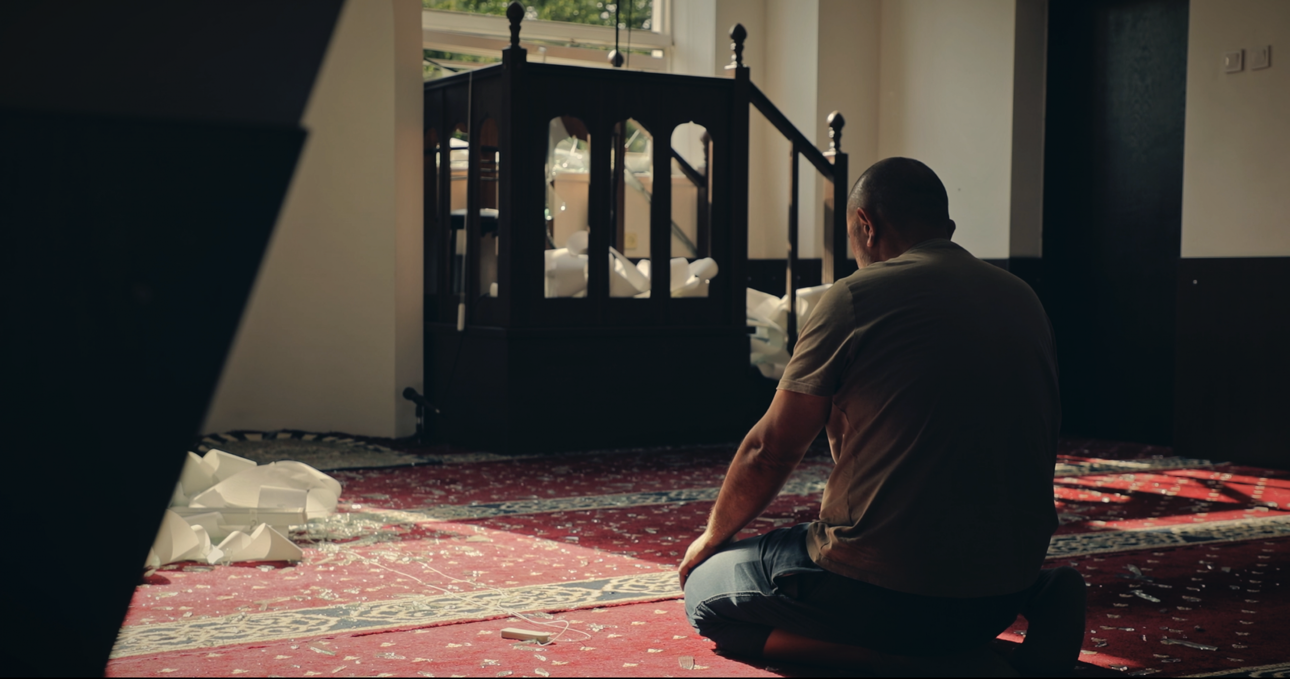 A man prays amid broken glass inside Kyiv’s Crimean Tatar mosque, damaged by a Russian missile strike.